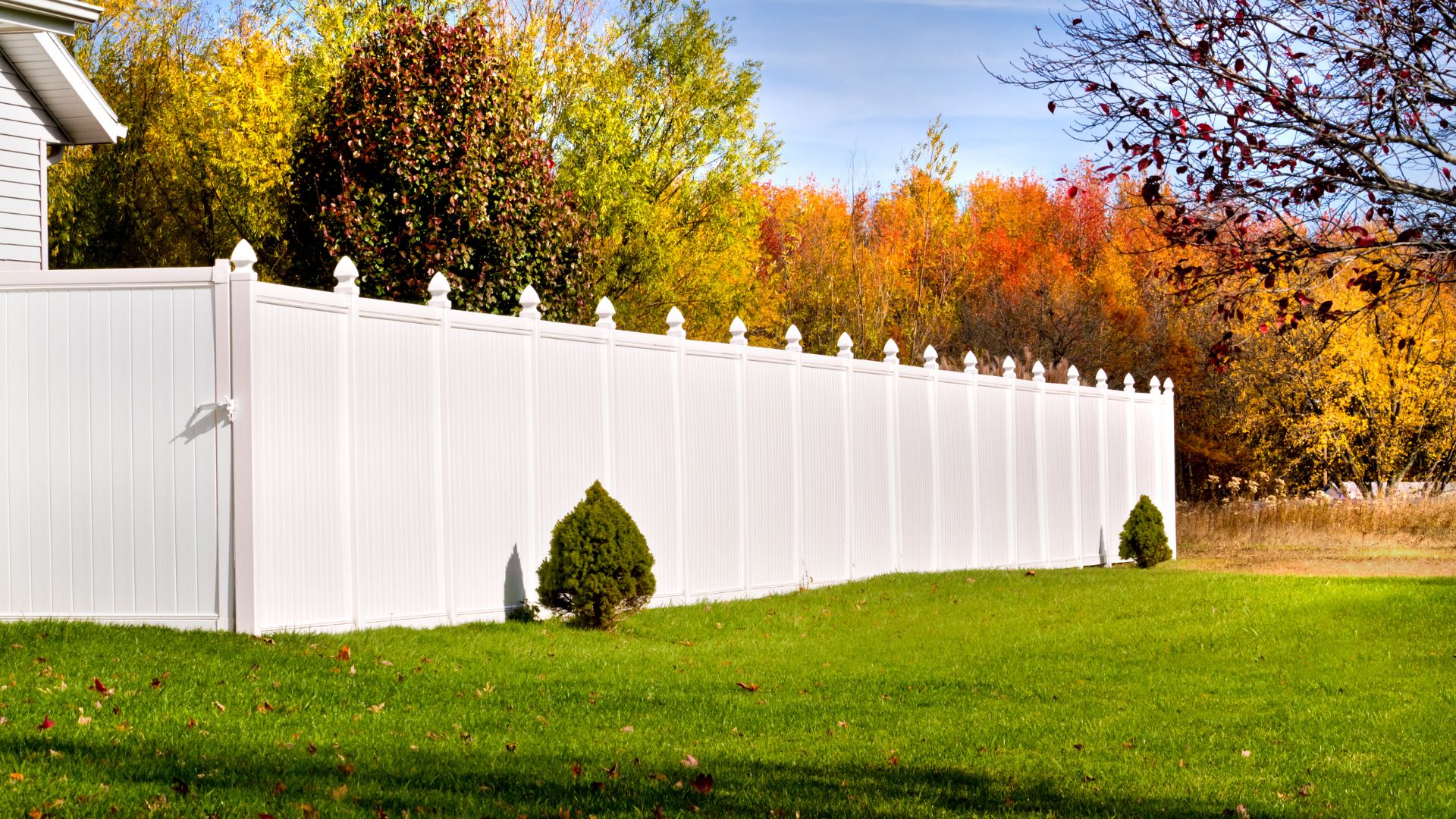 A white vinyl fence in front of a house