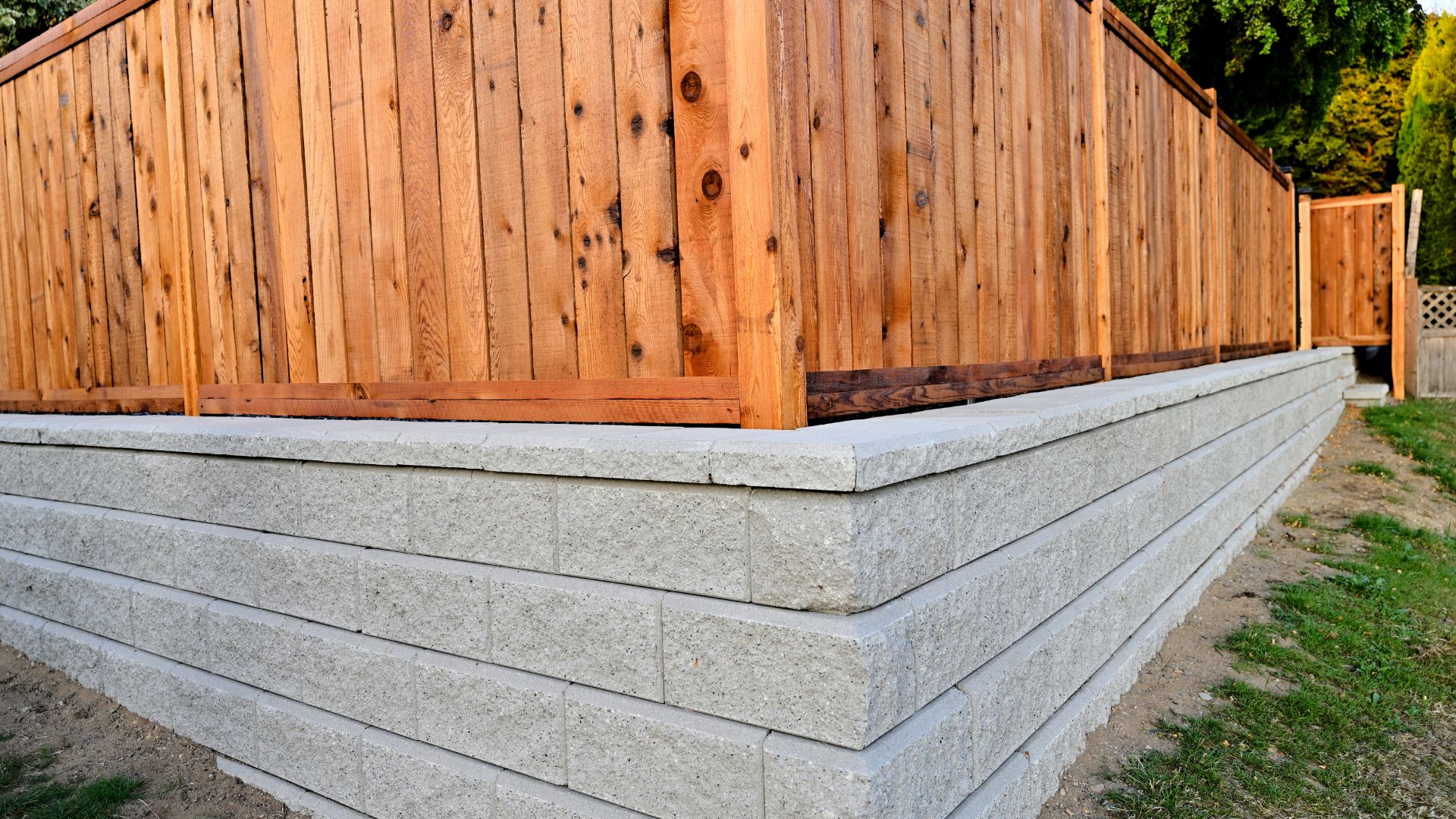 A wooden fence on top of a cement wall